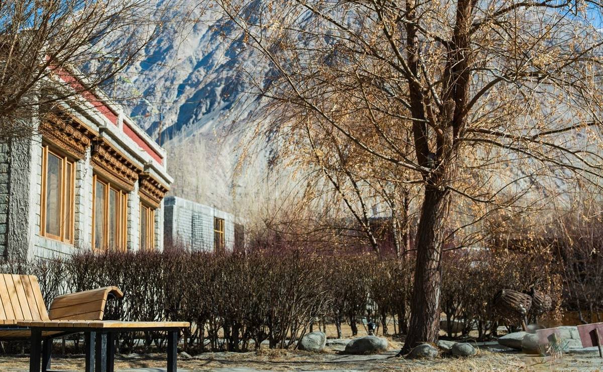Lchang Nang Retreat gardens against Nubra Valley mountains